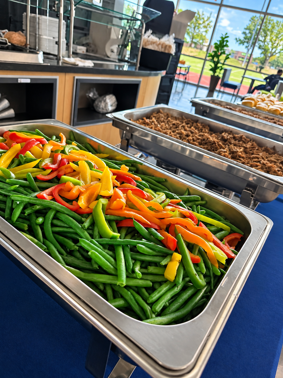 Luna Mesa Catering catering buffet with green beans and colorful peppers in chafing dishes