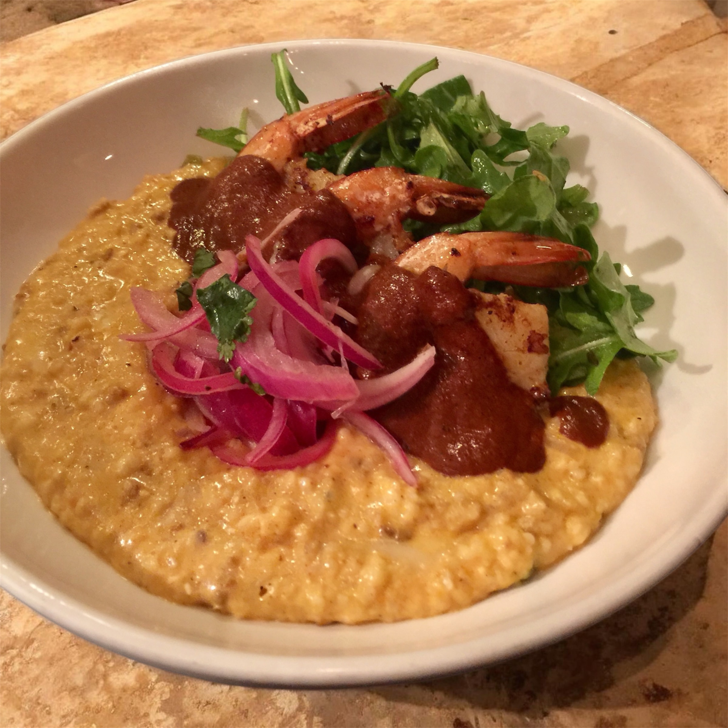 Luna Mesa Catering shrimp and grits with mole sauce, pickled red onions and arugula