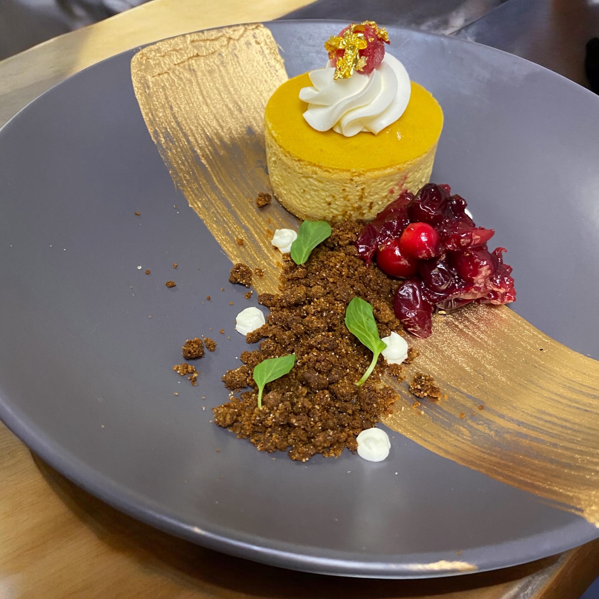 Luna Mesa Catering pumpkin cheesecake with gold leaf, cranberry compote, gingersnap crumble and whipped cream