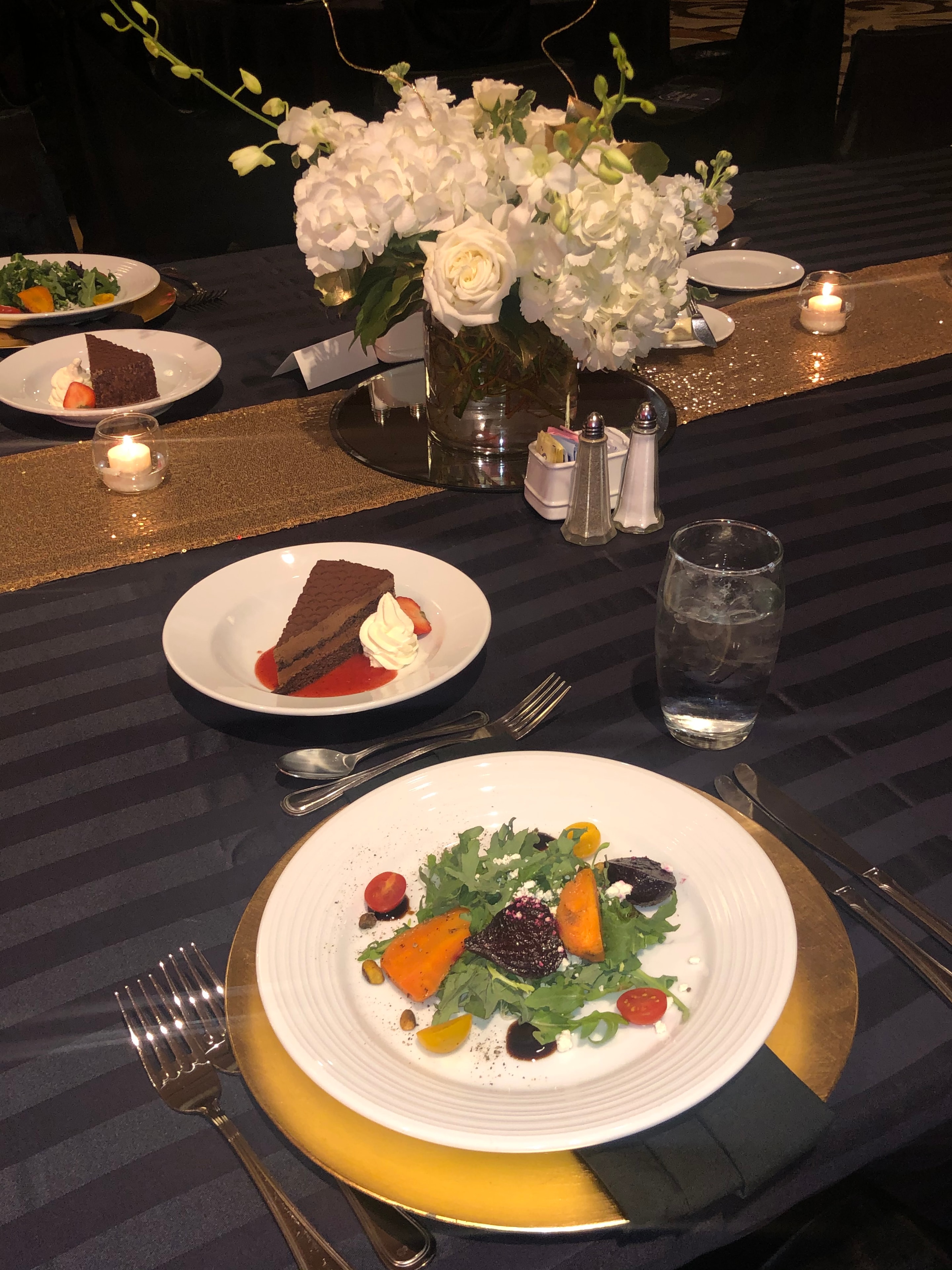 Luna Mesa Catering elegant event table setting with roasted beet and arugula salad, chocolate cake and white floral centerpiece