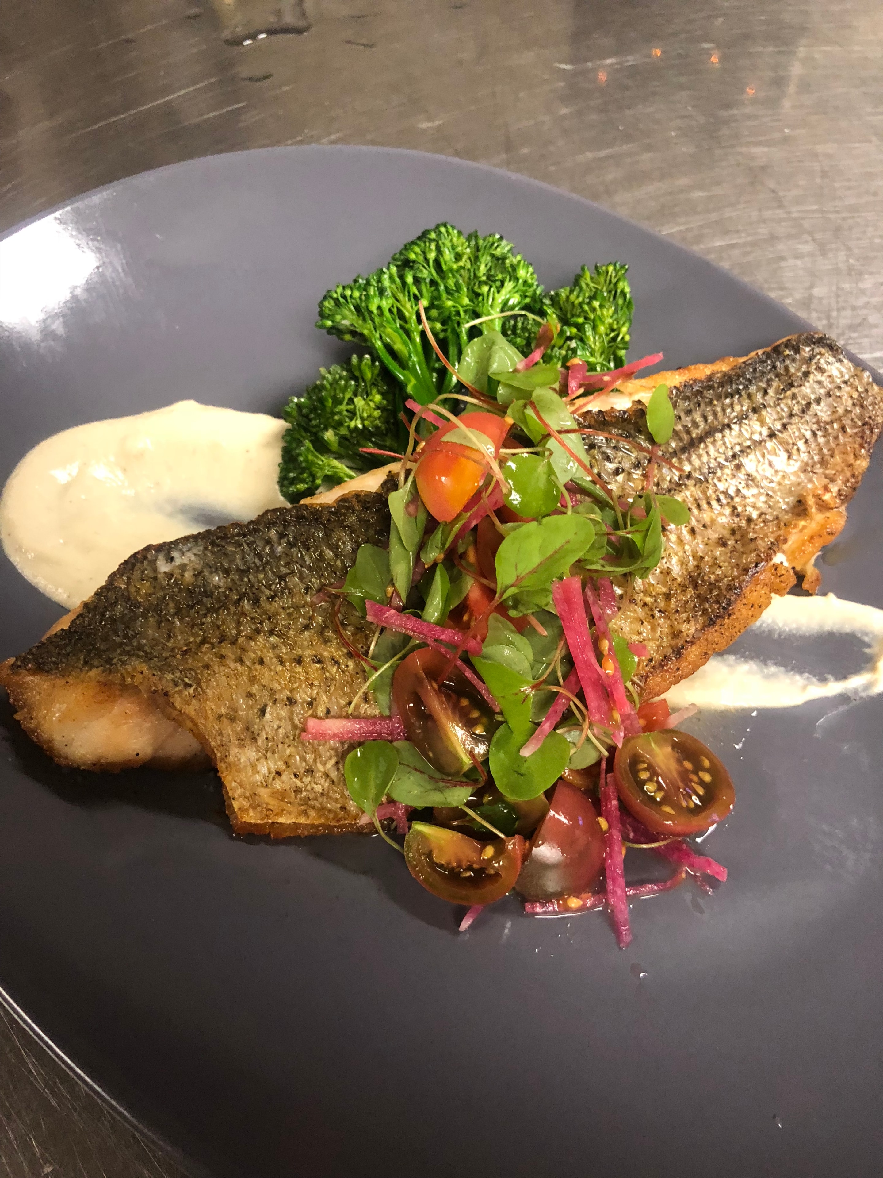 Luna Mesa Catering crispy skin sea bass over cauliflower purée with broccolini, heirloom tomatoes and pickled red onion